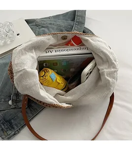 Detailed interior view of woven straw shoulder bag showing large storage capacity