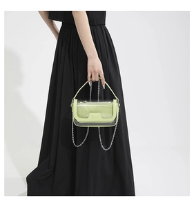 Détail du sac gelée vert clair translucide avec chaîne argentée et texture PVC moderne