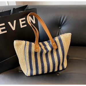 Detailed macro view of the striped woven straw texture and premium synthetic leather handle