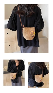 Detail of hand-woven straw bucket bag with 3D floral accents and leather strap