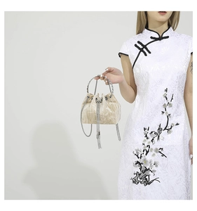 Detail of champagne velvet drawstring bucket bag with silver chain handle and fringe