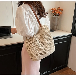 Detail of hand-woven crochet tote bag with premium brown leather shoulder straps