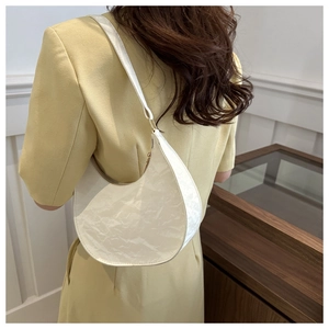 Detailed view of white hobo bag with wrinkled texture and gold metal buckle detail
