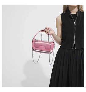 Detailansicht der transparenten rosa Umhängetasche mit Silberkette, von Model getragen