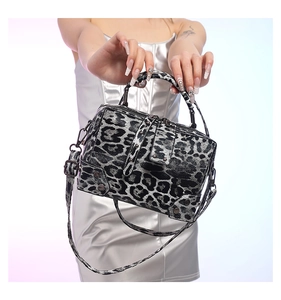 Close-up of leopard print crossbody bag with metallic zipper and leather texture details