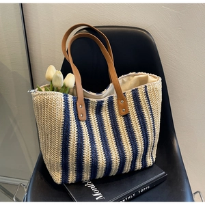 Detailed macro view of the striped woven beach tote with brown leather handles and rivets