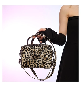 Detail of leopard print PU leather handbag with top handle and dark hardware on model