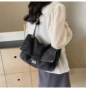Close-up of black washed denim crossbody bag featuring a silver metal turn-lock closure