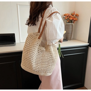 Detail of bohemian cream crochet tote bag with brown faux leather straps worn by model