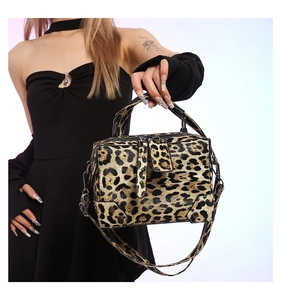 Detail of leopard print crossbody bag with metal zipper and adjustable strap