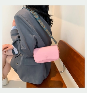 Detailansicht der rosa Handtasche aus Leder mit ethnisch gewebtem breitem Schultergurt