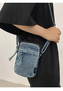 Detailansicht der gewaschenen Denim-Umhängetasche mit Kordelzugtasche und Reißverschluss