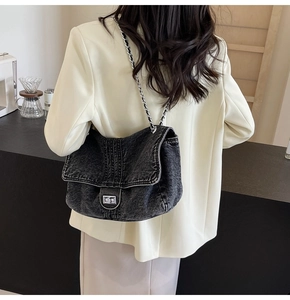 Chic black denim crossbody bag featuring silver turn-lock clasp and metal chain strap