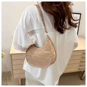 Detailed view of beige pleated crescent hobo bag with paper-texture and slim strap