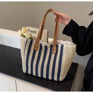 Detailed macro view of woven stripe texture and premium brown leather handle on tote bag