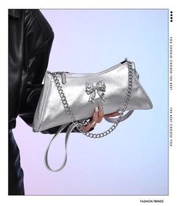 Detail of silver metallic handbag featuring textured PU leather and 3D bow accent