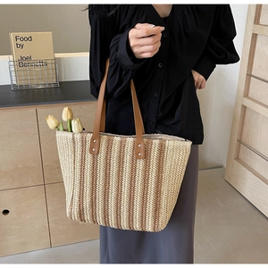 Detail of the woven vertical striped texture and leather handles on the vintage tote bag