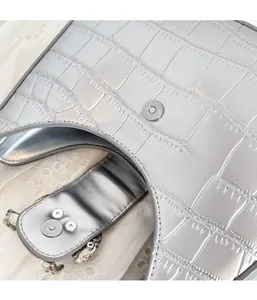 Detailed macro view of silver crocodile embossed PU bag featuring magnetic snap closure
