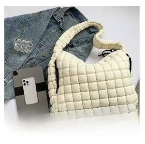 Macro shot of cream-white quilted cloud bag with puffy padding and square stitching