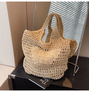 Detail of hand-woven beige cotton rope tote bag with minimalist mesh design on black surface