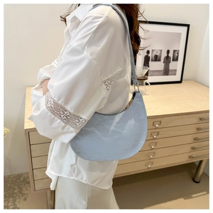 Detail shot of light blue PU leather crescent bag with gold zipper and smooth texture