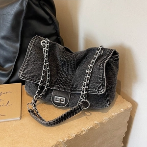 Minimalist washed denim crossbody bag with silver turn-lock and metal chain strap