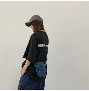 Streetstyle-Ansicht einer blauen Denim-Umhängetasche kombiniert mit einem modischen Outfit