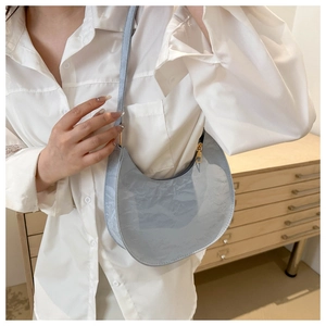 Chic light blue pleated crescent shoulder bag shown on model for a trendy casual style