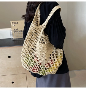 Detail of hand-woven straw tote bag showing beige mesh texture and crochet craftsmanship