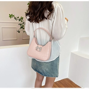 Pink faux leather half-moon shoulder bag with crocodile pattern and diamond bow detail