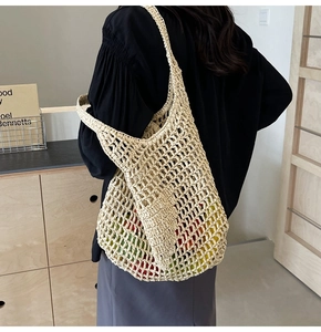 Detail of handmade cream crochet tote bag with woven mesh hollow structure shown on shoulder