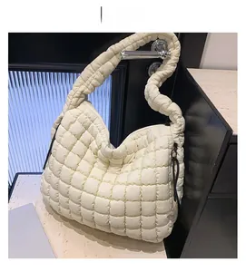 Detail view of the white quilted cloud bag featuring square puffer texture and wide strap