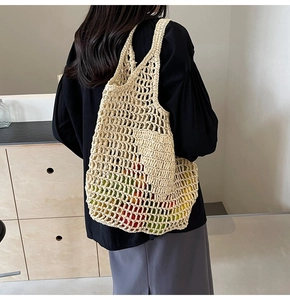 Detail view of beige woven straw tote bag with honeycomb hollow design and shoulder strap