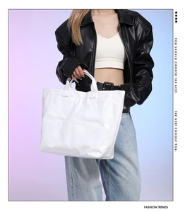 Fashionable white DuPont paper tote bag with unique crinkled texture worn by a model