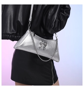Detail view of metallic silver PU crossbody bag with vintage silver bow buckle