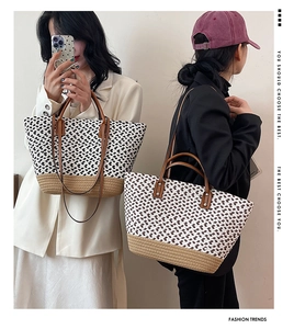 Detail of woven tote bag with geometric patterns, leather handles and long shoulder strap