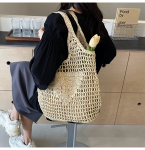 Close-up of beige woven straw tote bag with intricate diamond mesh texture and tulips