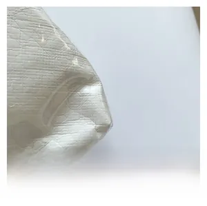 Detailed macro view of white lychee pattern fabric with protective plastic film overlay
