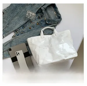Close-up detail of white Tyvek tote bag with wrinkled texture and printed logo in a lifestyle setting