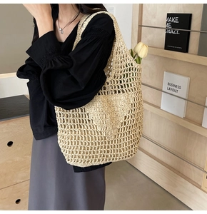 Detail of hand-woven straw mesh tote bag showing the natural texture and hollow out pattern