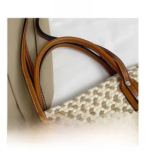 Detailed close-up of brown leather handle and woven texture on a boho beach tote bag