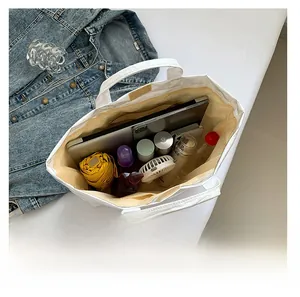 Macro view showing large capacity of the white Tyvek tote bag with daily essentials