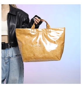 Detailed view of the Tyvek tote bag with clear PVC waterproof outer layer and white lettering