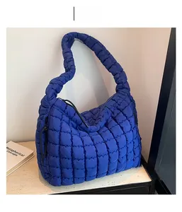 Detail of deep blue quilted hobo bag featuring soft puffy texture and nylon fabric