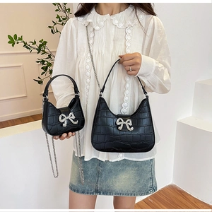 Detail of black crocodile texture handbags with sparkling silver rhinestone bow accents