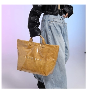 Detail of waterproof PVC tote bag with wrinkled paper texture and white TOTE BAG text