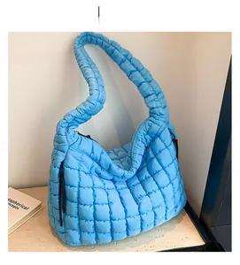 Detail showing the light blue quilted cloud tote bag with puffy square textures and wide strap