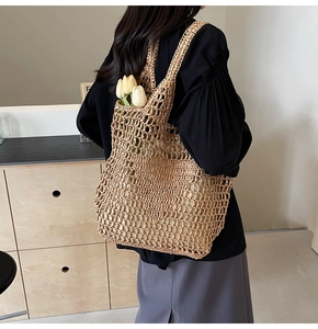 Detail of hand-woven straw tote bag with mesh hollow design and long shoulder strap