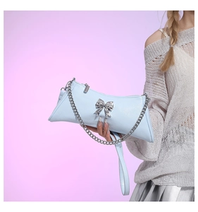 Close-up of light blue textured PU leather bag featuring a silver bow metal clasp