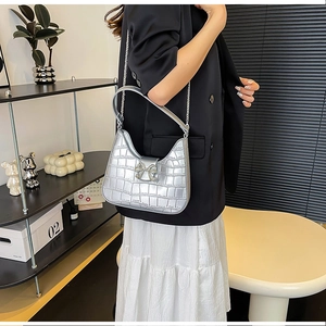 Detail of silver crocodile pattern PU leather bag with rhinestone bow buckle and chain